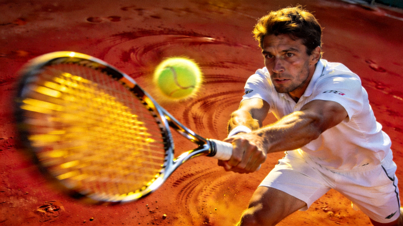 网球运动员在红土场上奋力击球的动作